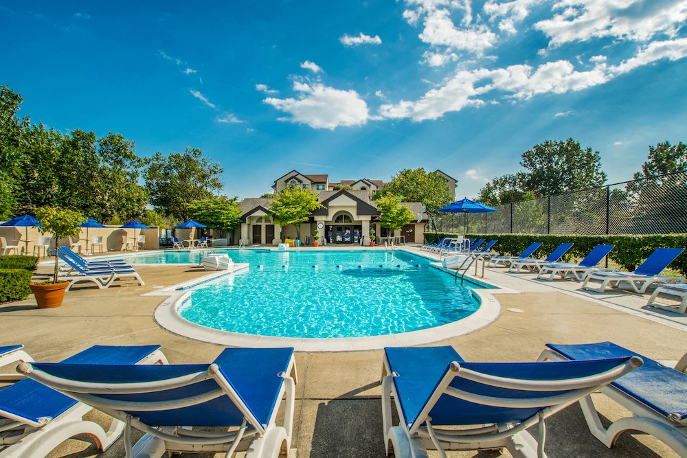 our resort style pool is filled with lounge chairs and umbrellas