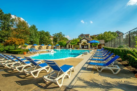 our resort style swimming pool is filled with blue and white deck chairs
