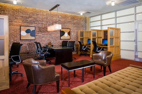 a conference room with leather chairs and a brick wall