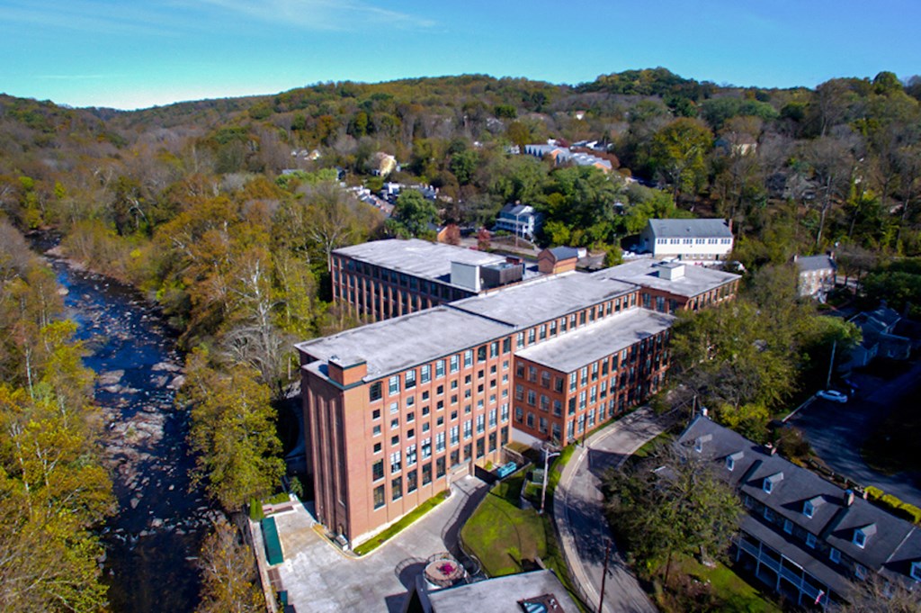 an aerial view of a large brick building next to a river