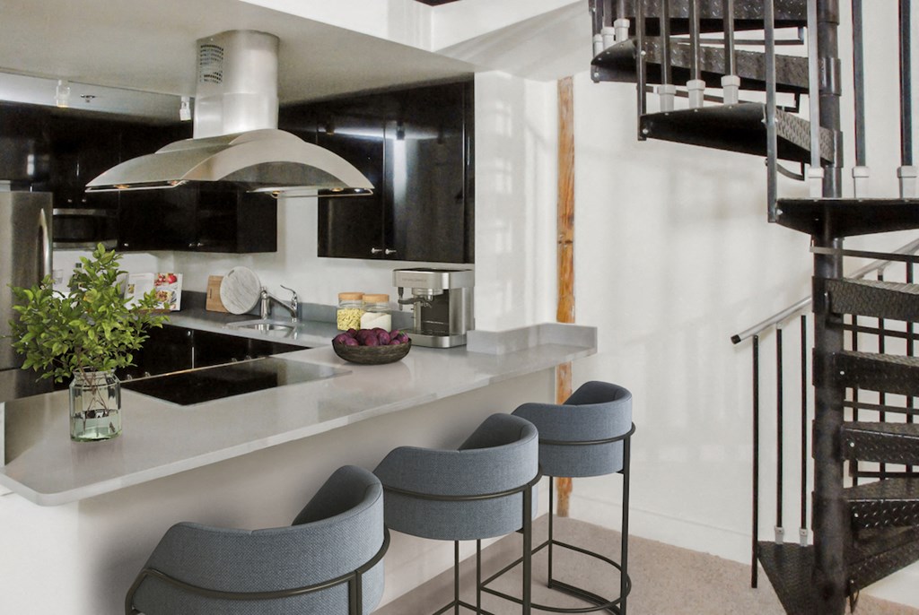 a kitchen with a counter and chairs and a spiral staircase