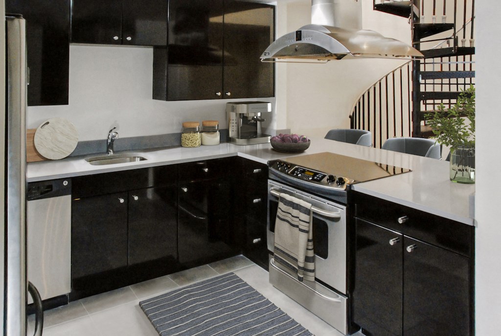 a kitchen with black cabinets and a stainless steel stove