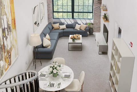 a living room with a blue couch and a table and chairs