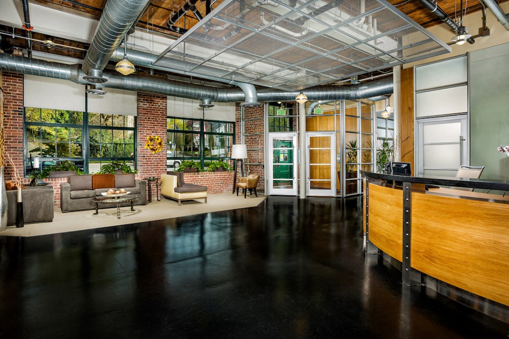 the lobby of a building with a living room and a reception desk