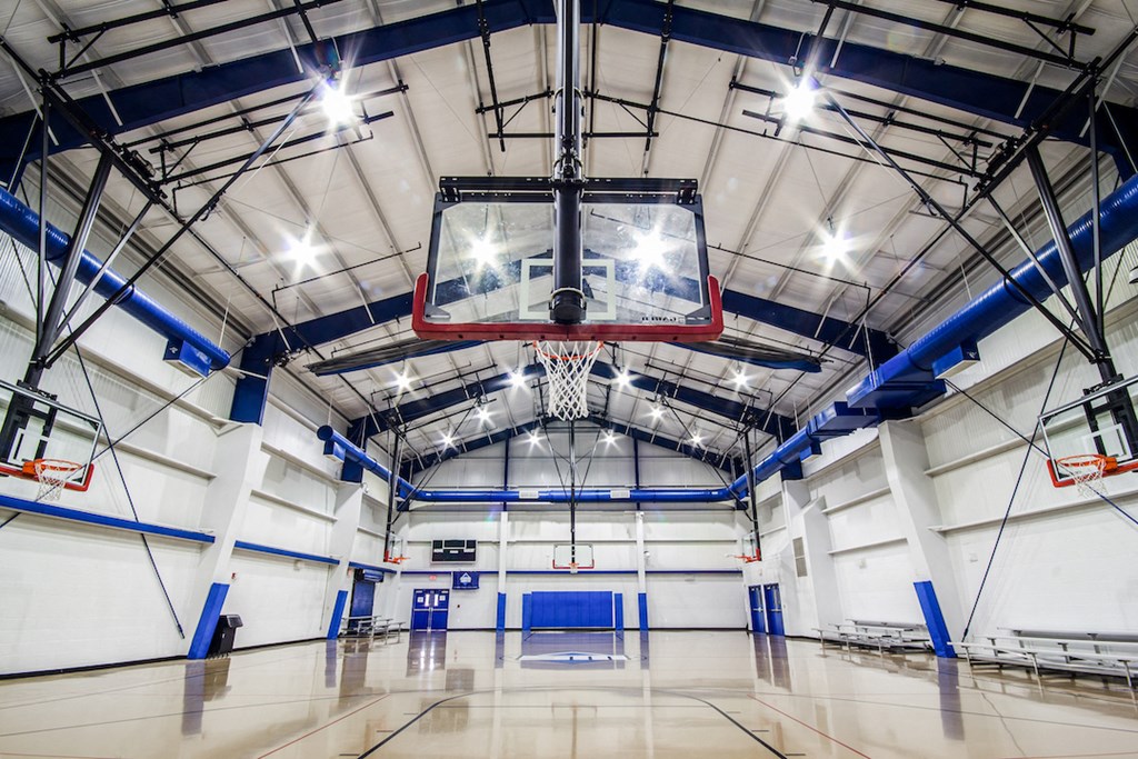 a basketball hoop hangs from the ceiling of a large gymnasium