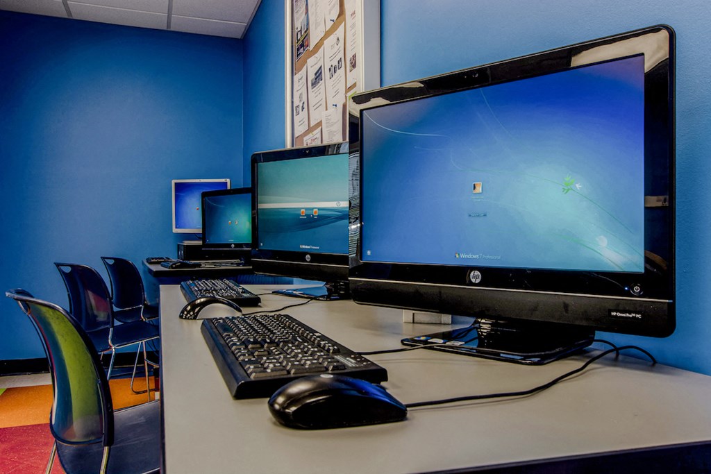 a computer desk with three monitors and a keyboard and mouse