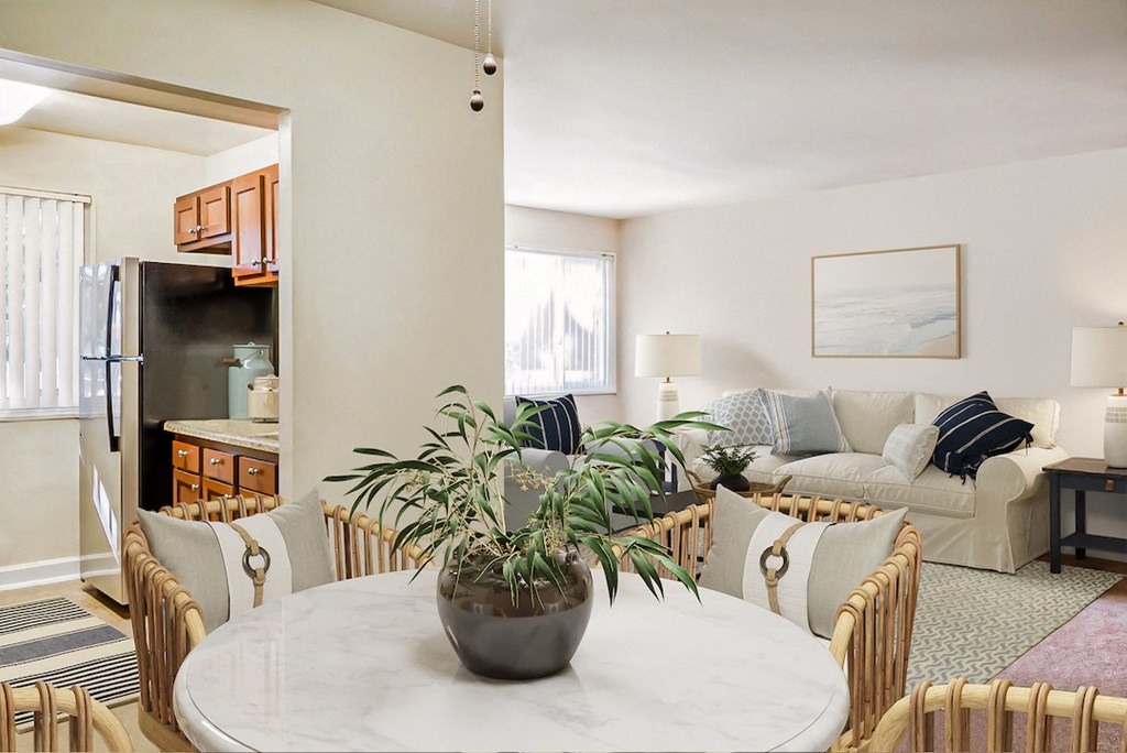 a living room and dining room with a white marble table and a plant