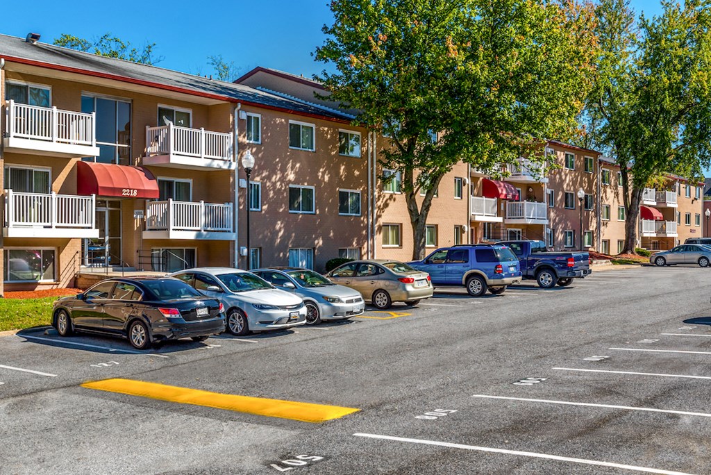 an empty parking lot in front of an apartment building