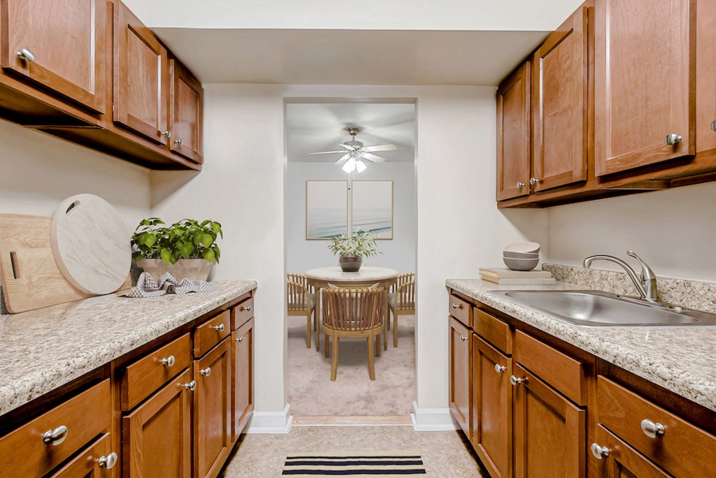 a kitchen with wooden cabinets and granite counter tops and a dining room with a table