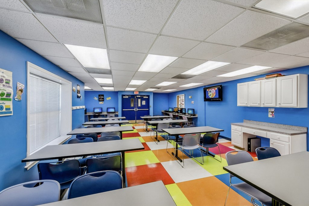 a classroom with tables and chairs and a fire place