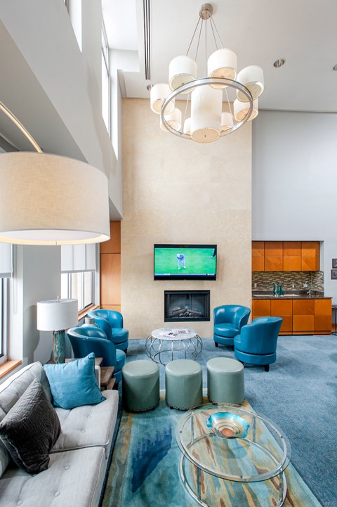 a large living room with blue chairs and a fireplace