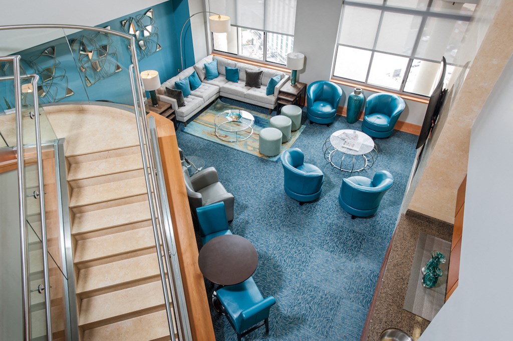 a lobby with couches and chairs and a staircase