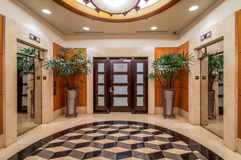 a lobby with doors and potted plants