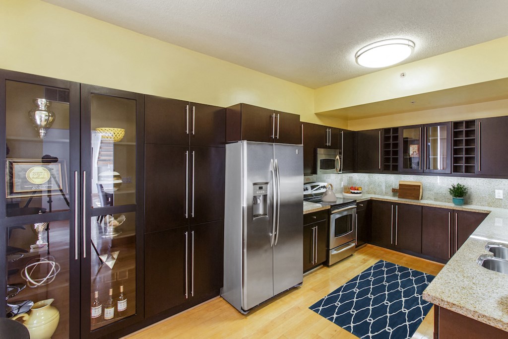 a kitchen with stainless steel appliances and dark wood cabinets