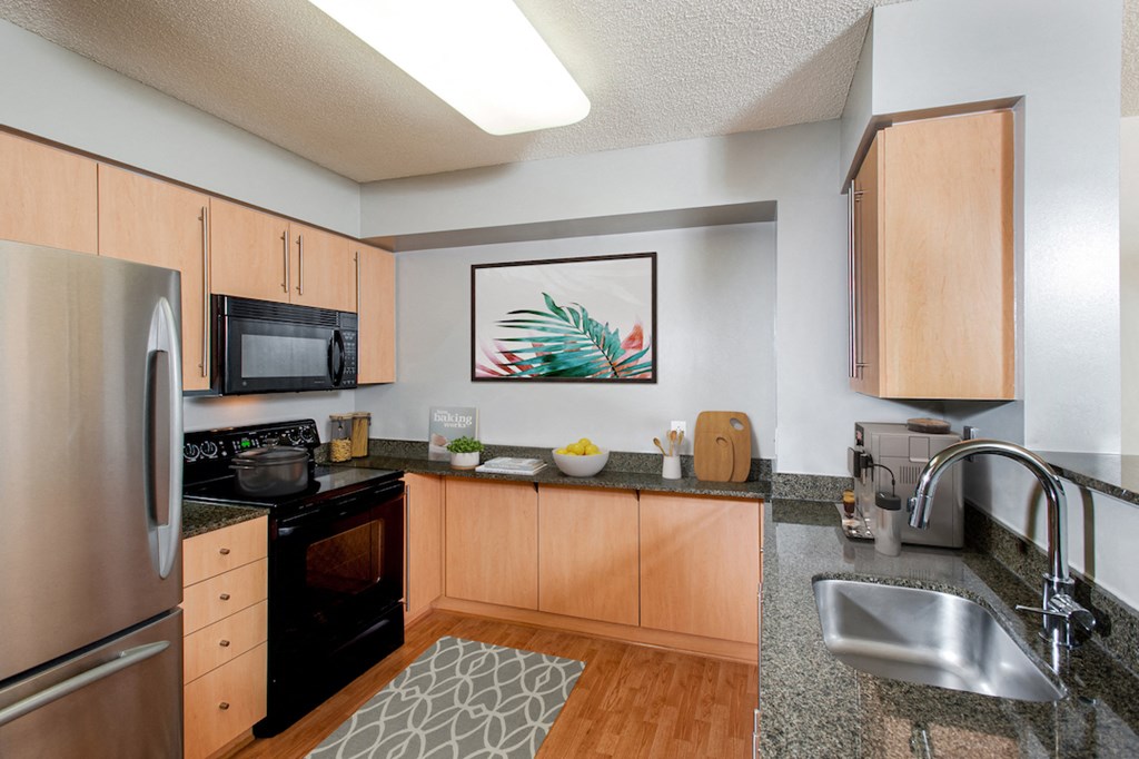 full kitchen with granite countertops and stainless steel appliances at the flats at west end