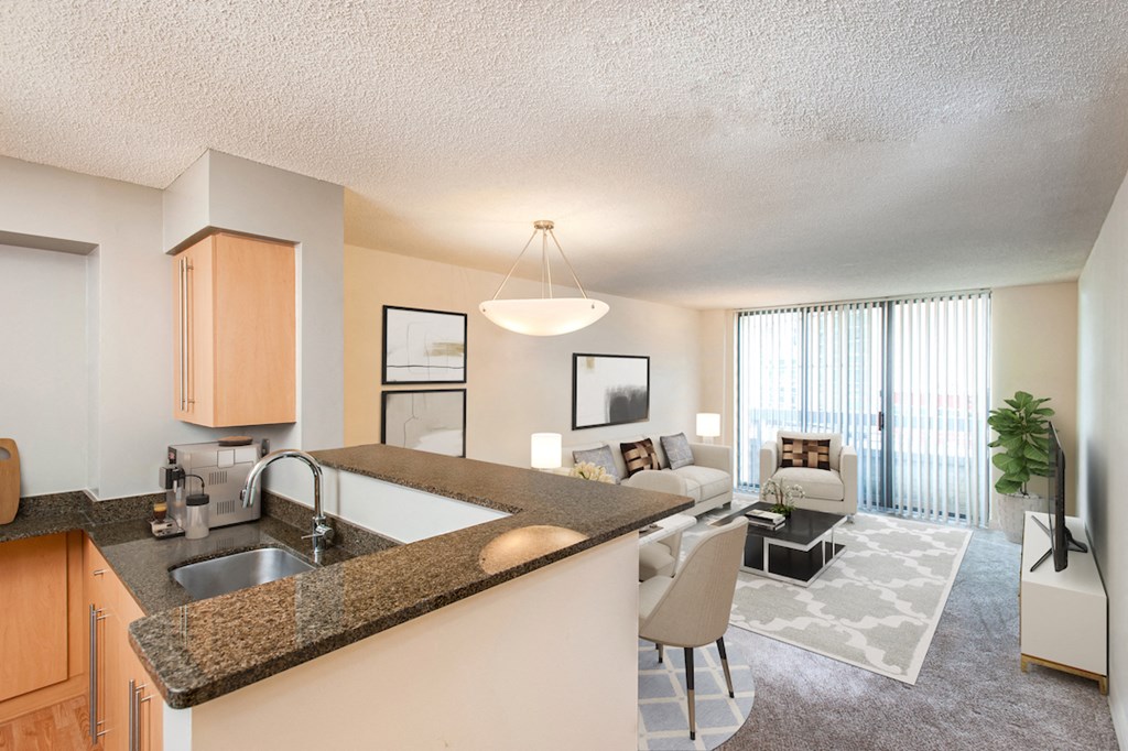 the view of a living room and a kitchen with a granite counter top