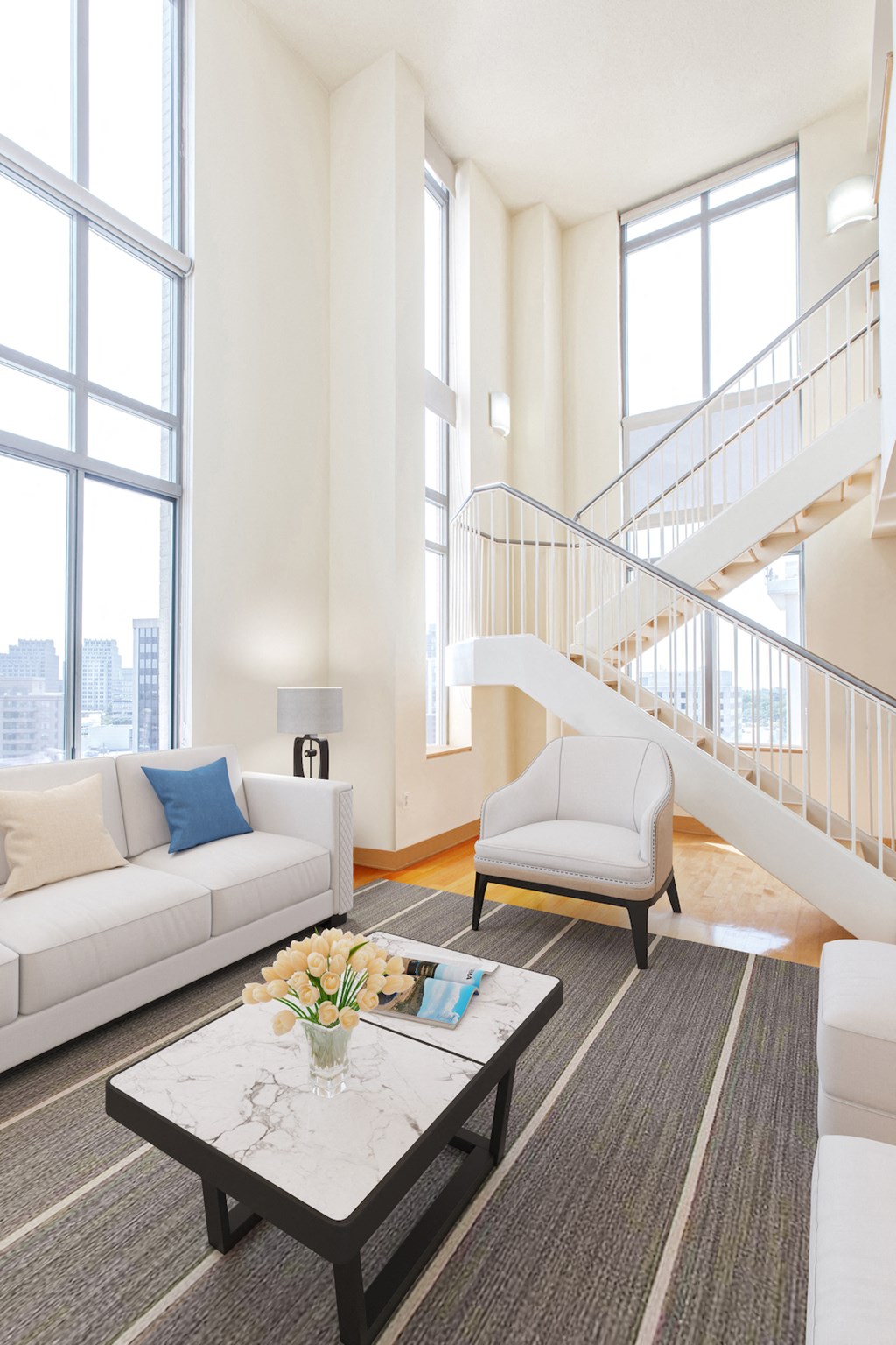 a living room with couches and a coffee table and a staircase