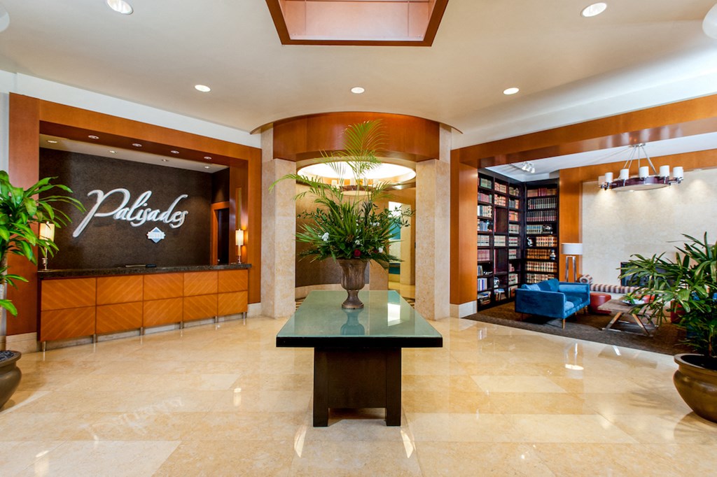 a lobby of a hotel with a plant in the center