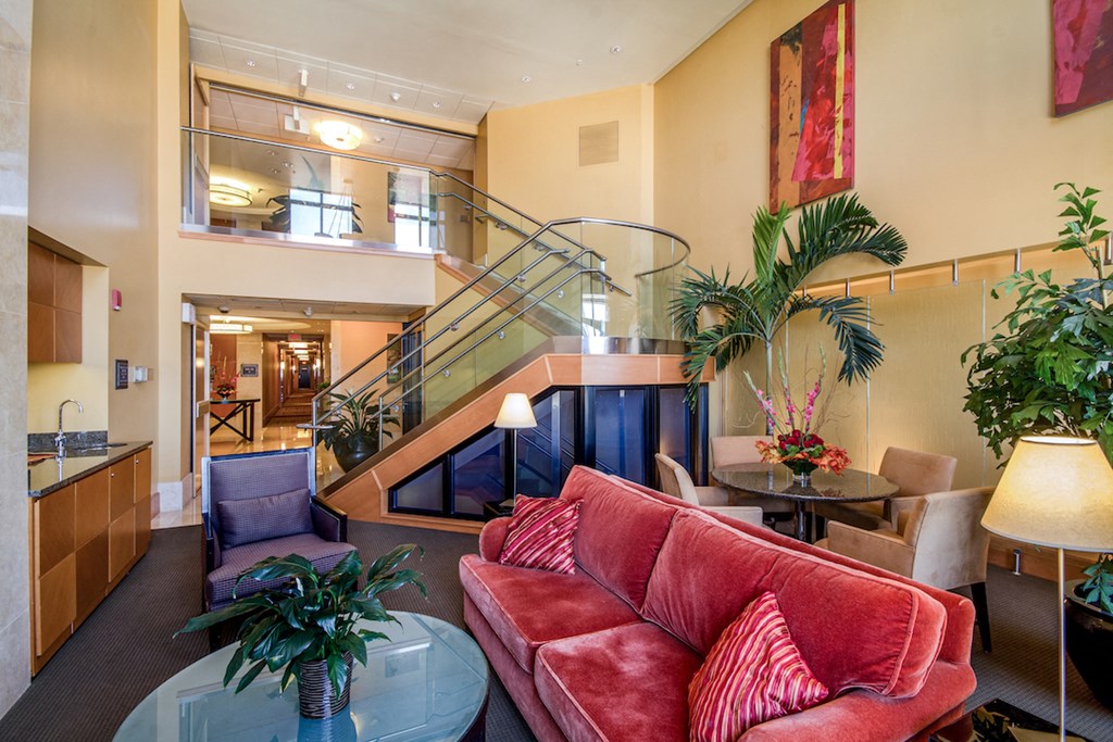 a living room with a red couch and a glass table