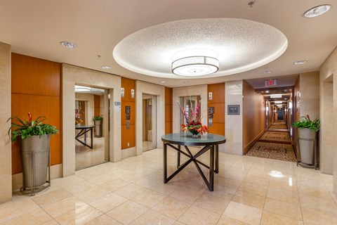a lobby with a table with flowers in the middle