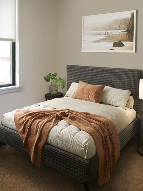 a bedroom with a bed and a painting on the wall