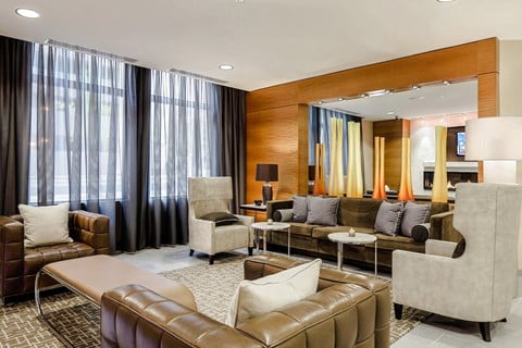 a living room with leather couches and chairs and a large mirror