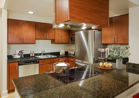 a kitchen with granite counter tops and a stainless steel refrigerator