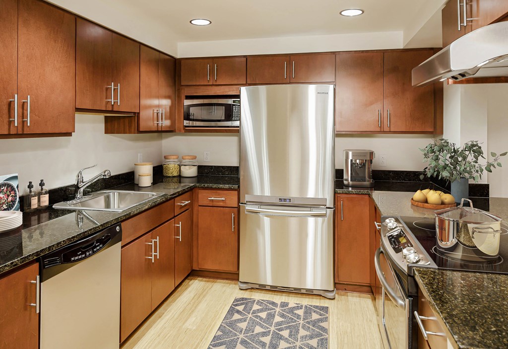 a large kitchen with stainless steel appliances and wood cabinets