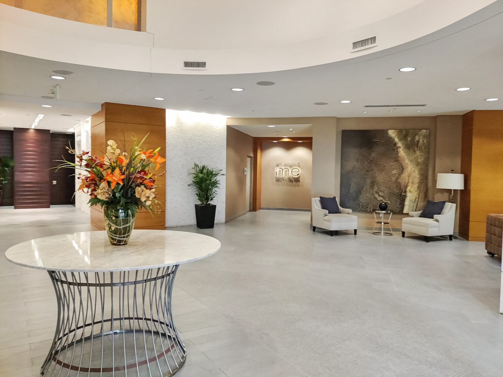 the lobby of a hotel with a vase of flowers on a table