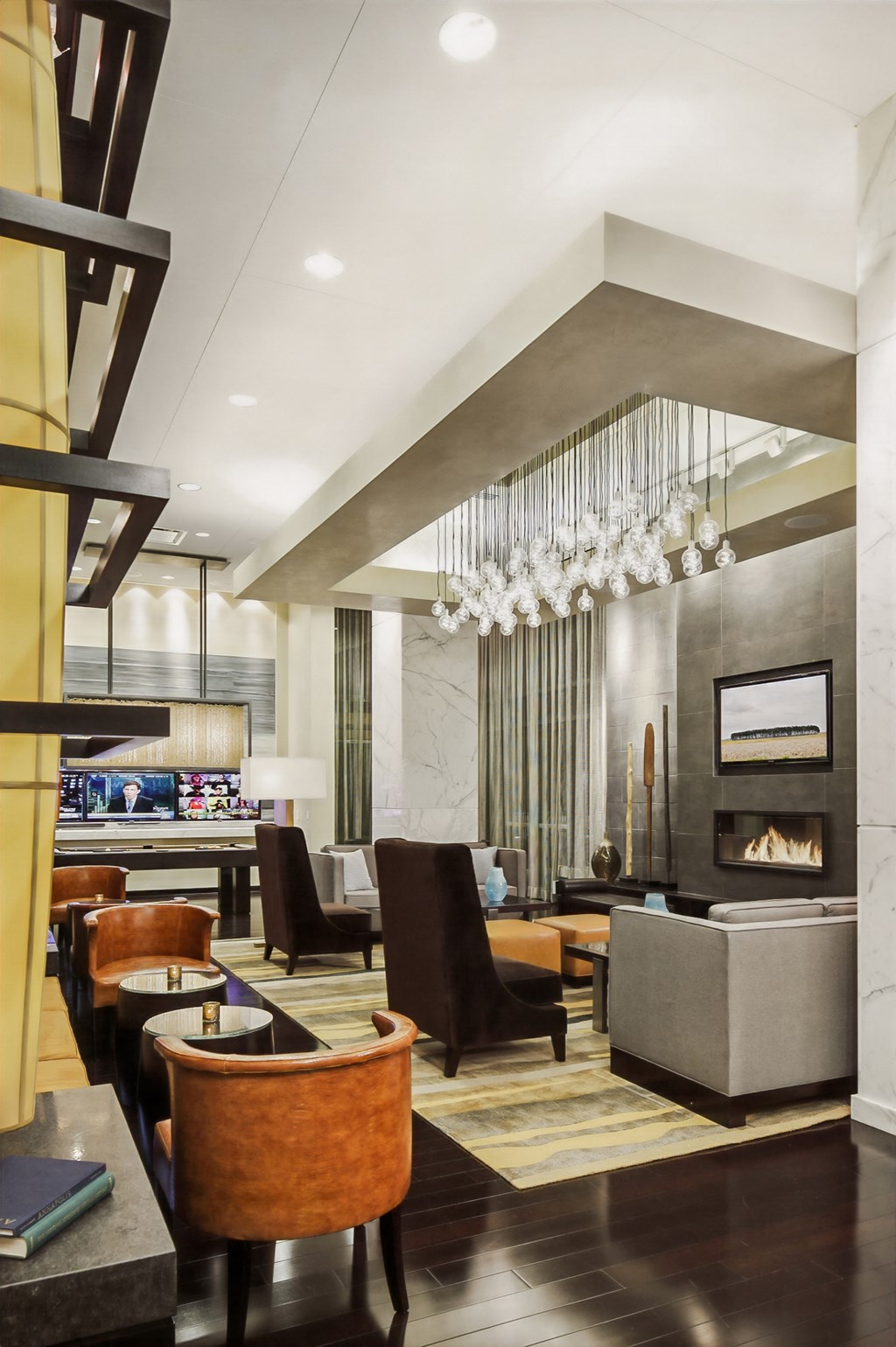 a living room with chairs and a fireplace and a bar