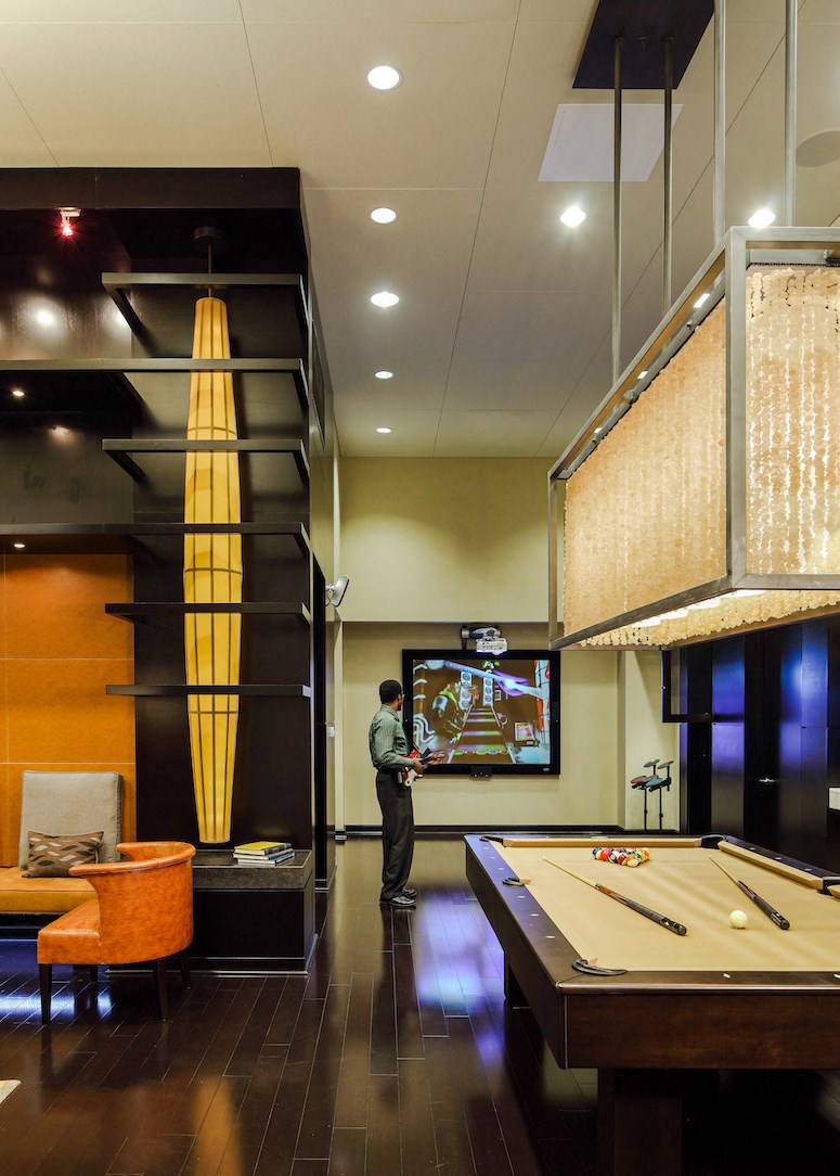 a man playing a video game in a room with a pool table
