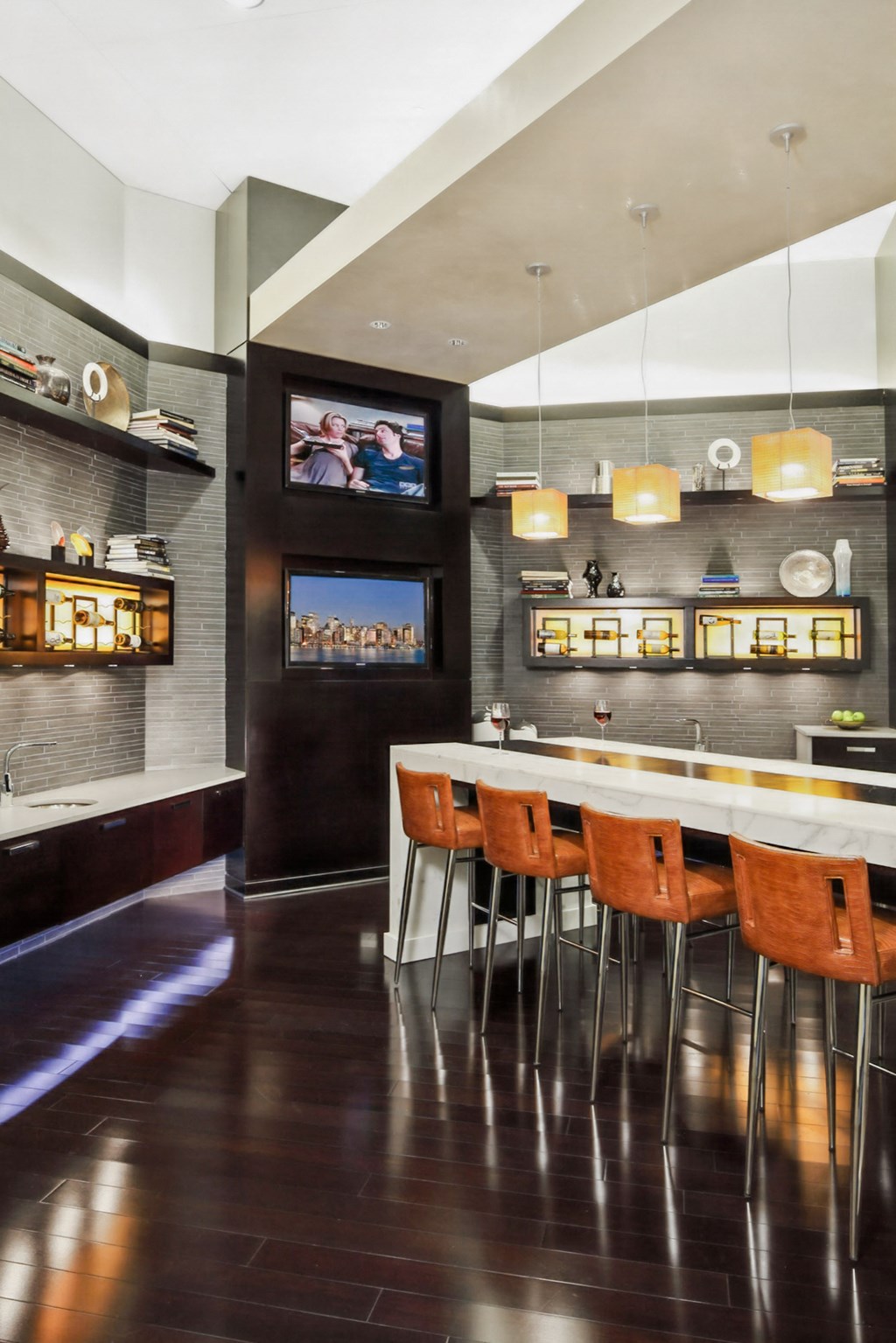 a kitchen with a bar and chairs and a television
