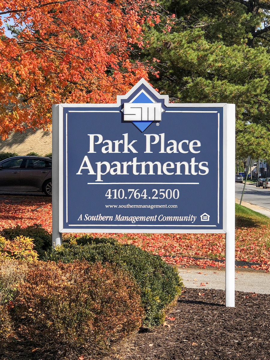 a park place apartments sign on the side of a sidewalk