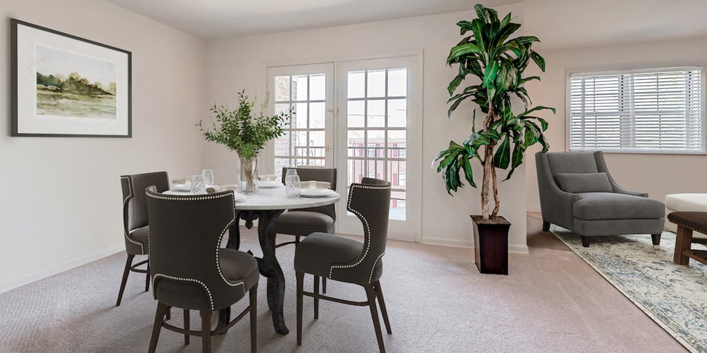 a dining room with a table and chairs and a plant