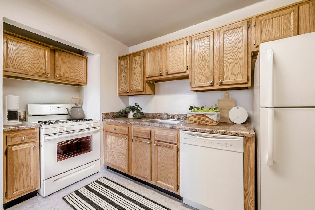 a kitchen with white appliances and wooden cabinets