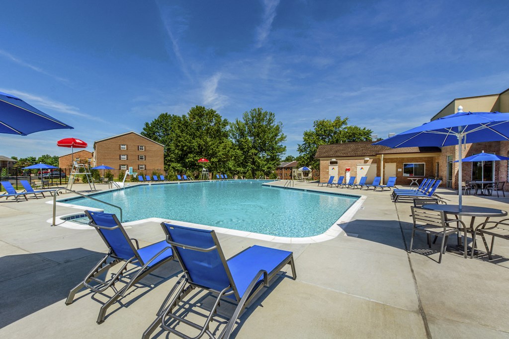 our apartments have a resort style pool with blue chairs and umbrellas