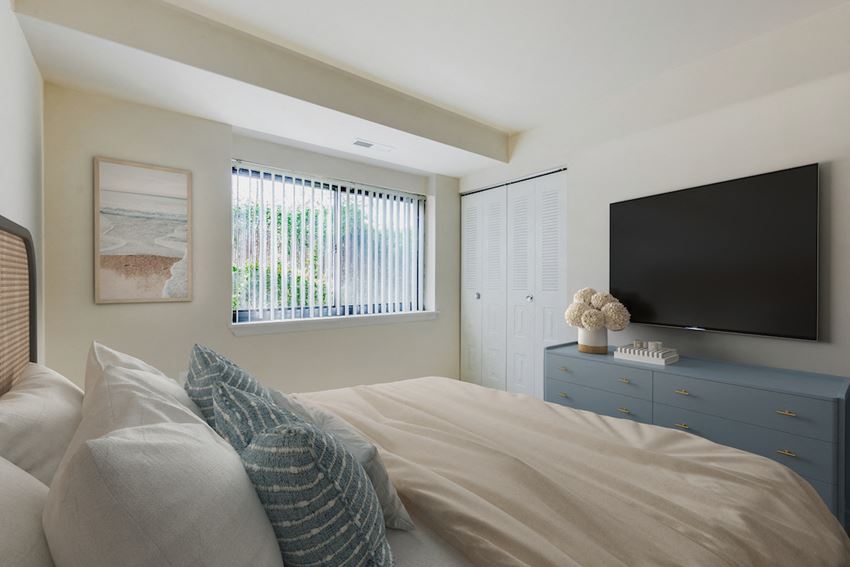 the master bedroom has a large bed and a tv