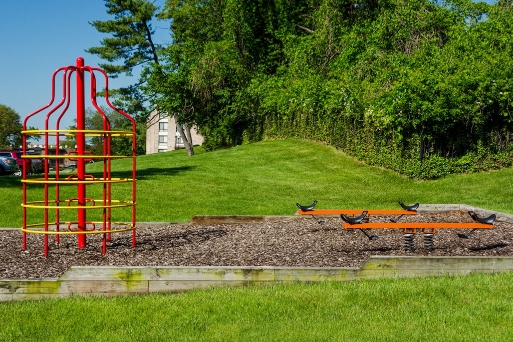 a playground with a red tower and a bench