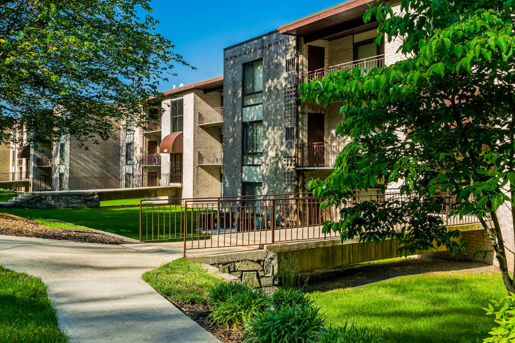 a building with a sidewalk in front of it and a tree