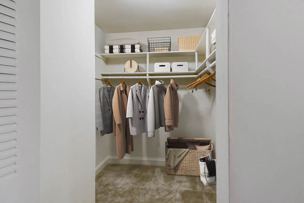 a walk in closet with shelves and clothes