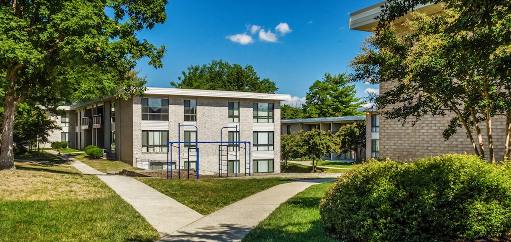a building with a playground and a sidewalk in front of it