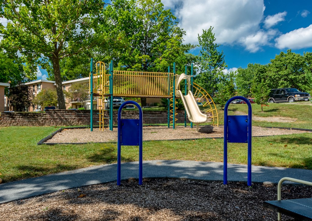 a playground with a slide and swings at a park