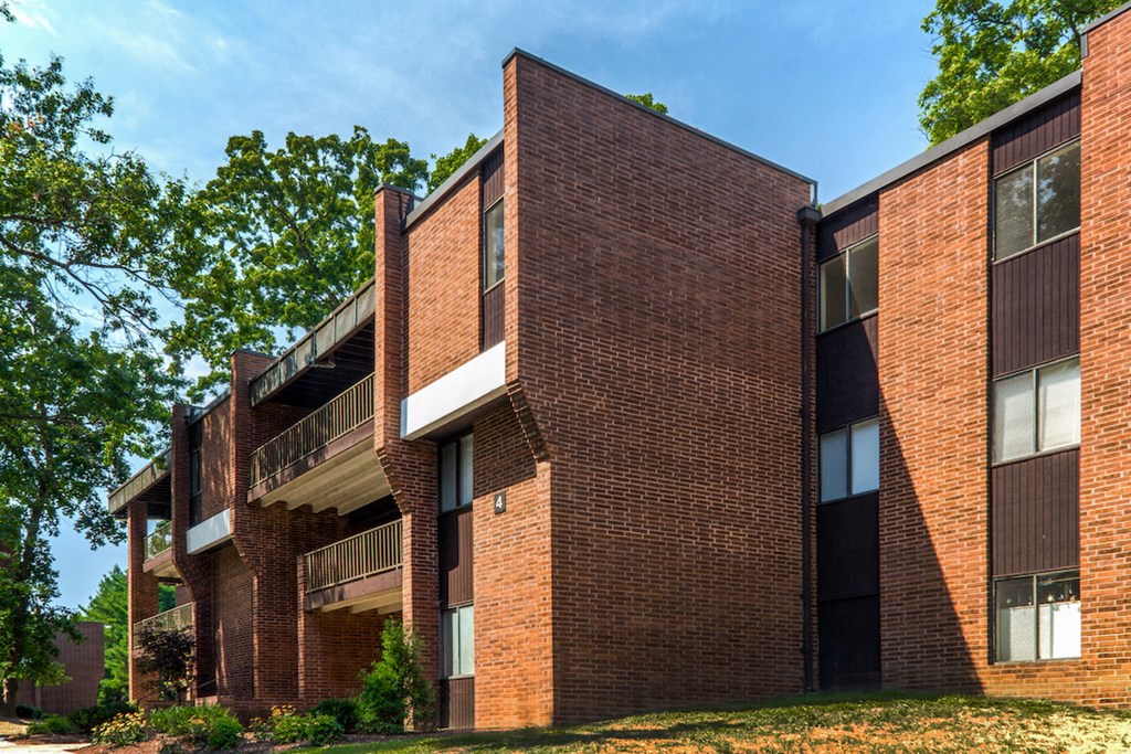 the exterior of a brick building with grass and trees