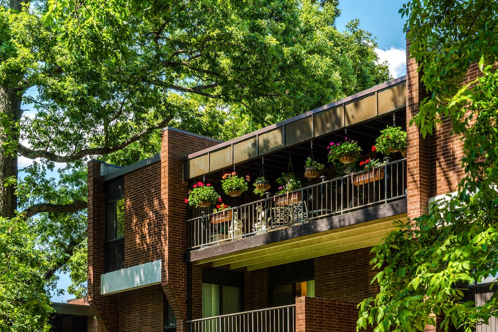 a red brick building with flowers on the balcony
