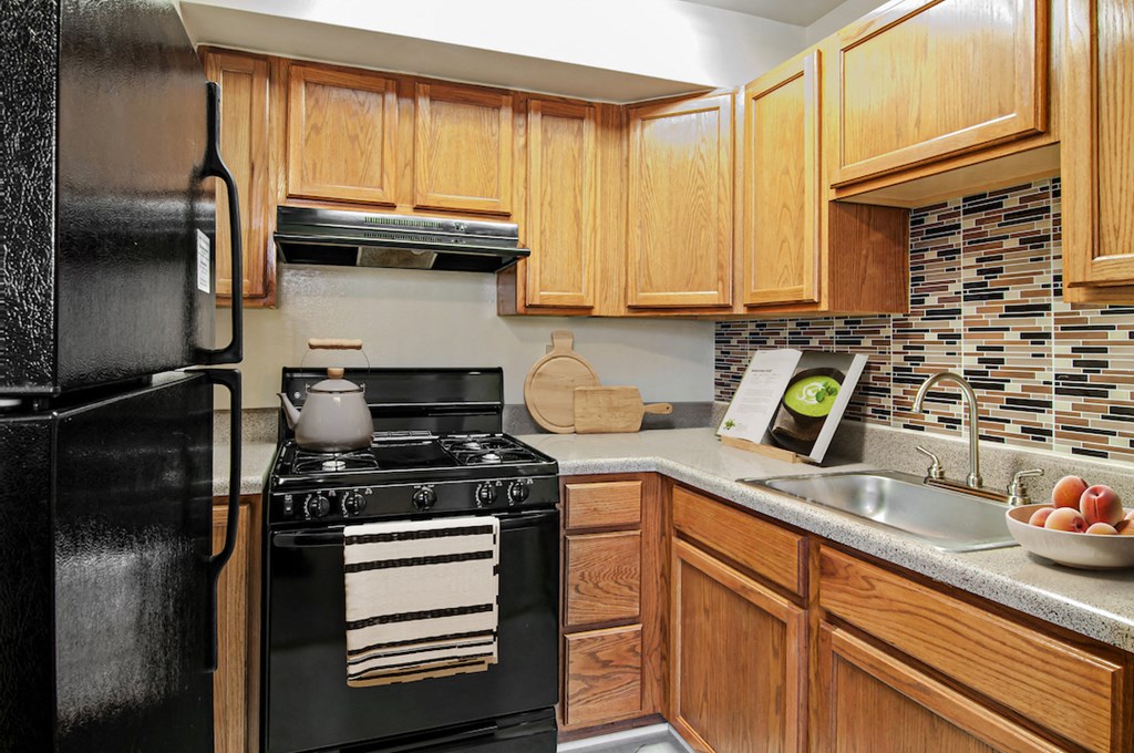 a kitchen with black appliances and wooden cabinets