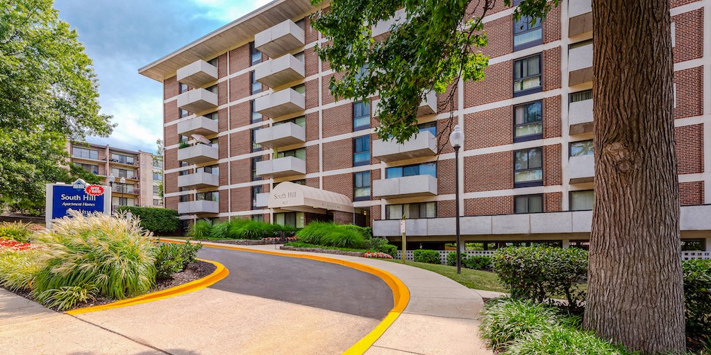 a curved street in front of an apartment building