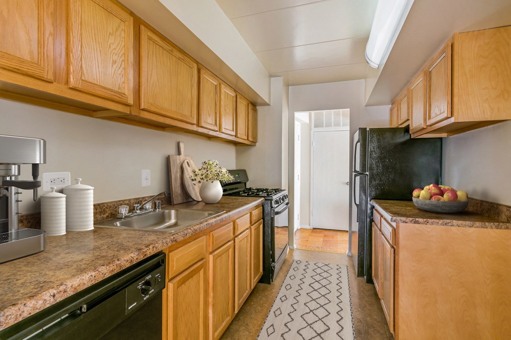 a kitchen with black appliances and wooden cabinets and counter tops