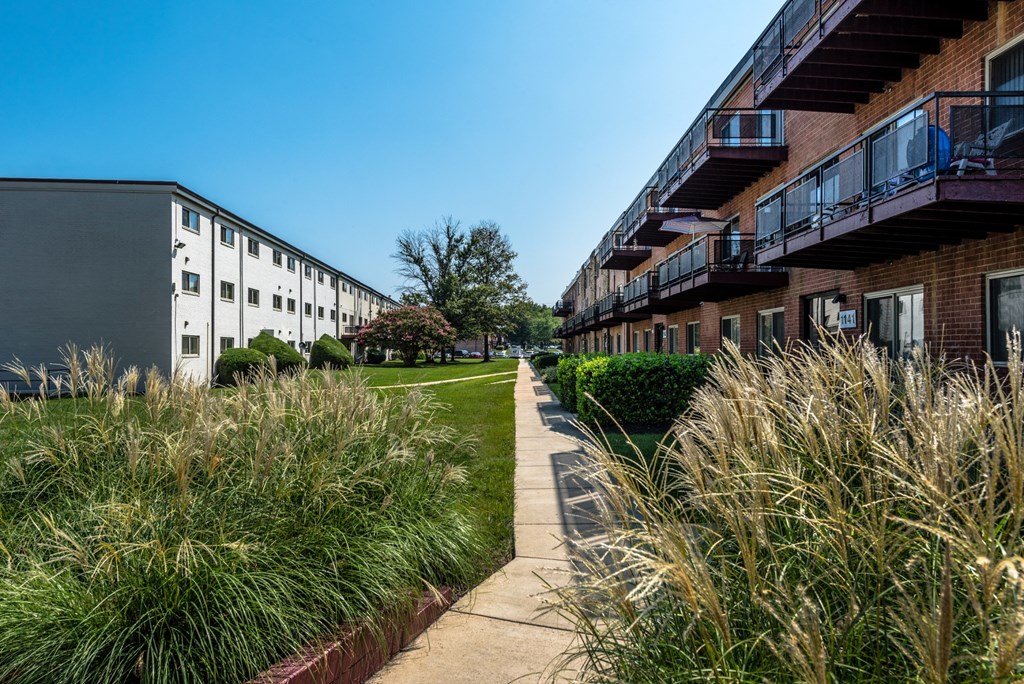 a sidewalk in front of a row of apartment buildings