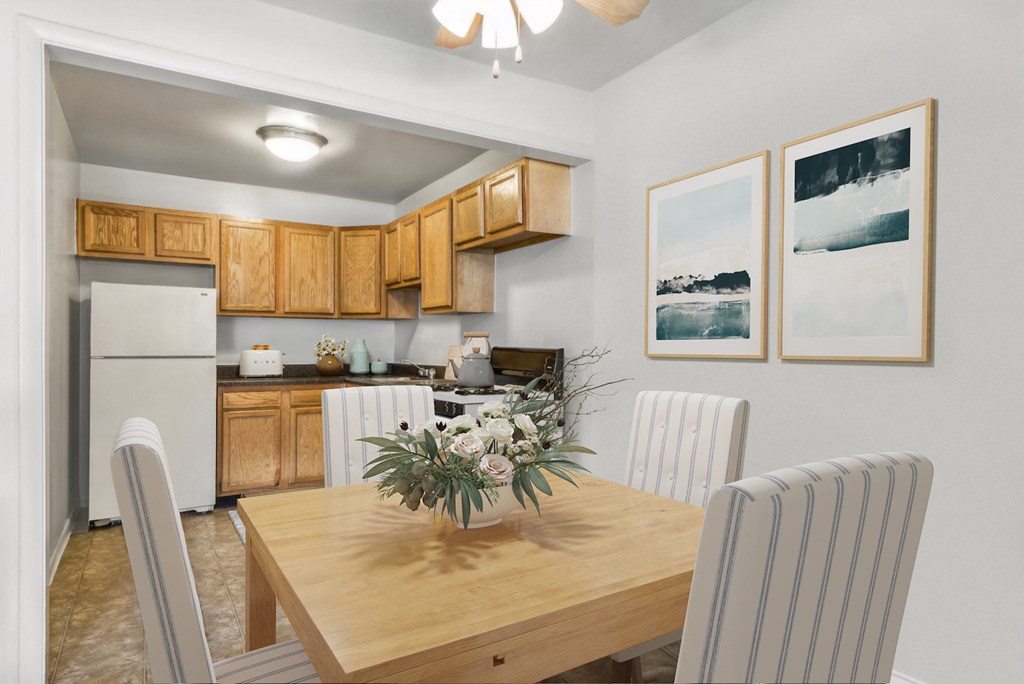 a dining room with a wooden table and chairs and a kitchen with a refrigerator