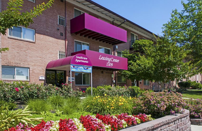 the exterior of leasing center iv with flowers in front of the building